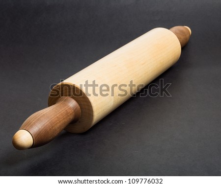 Wooden maple rolling pin on black bakery table