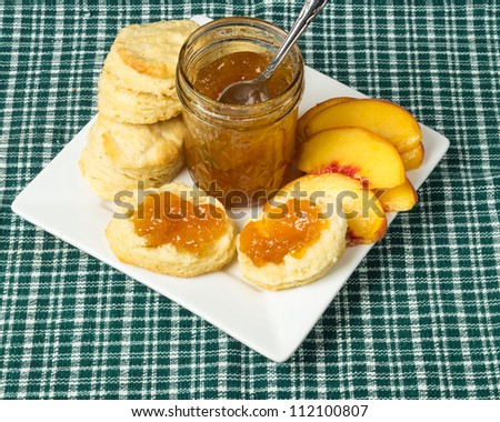 Peach jam or jelly with biscuits and peaches