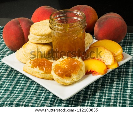 Plate of biscuits with peaches and peach jam or jelly