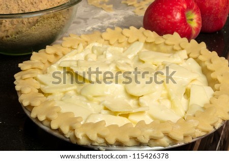 Apple pie with apples and bowl ready for the oven