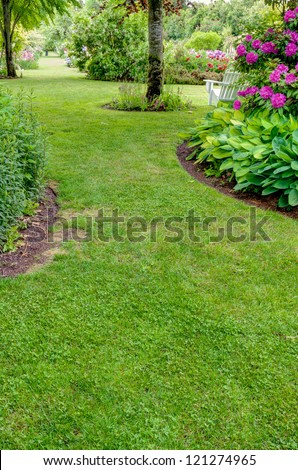 A grass walkway leads through a blooming garden