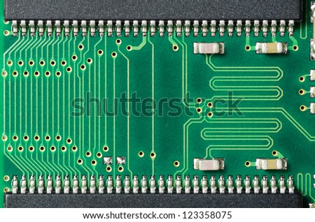A closeup of a printed circuit board with silver solder points
