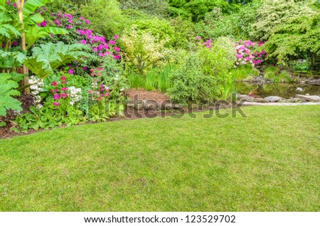 A garden scene with pink azaleas and a reflecting pool