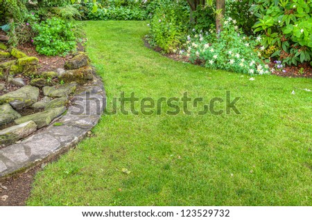 A garden scene with stone edged flower beds