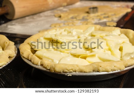 An unbaked apple pie shell with apple slices ready for the oven