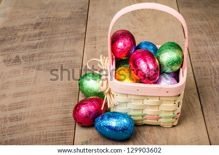 A small wicker Easter basket with foil chocolate eggs
