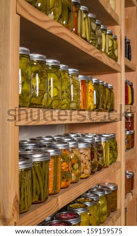 Canned goods on wooden storage shelves in pantry