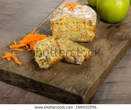 Carrot apple cake on wooden table with shredded carrots