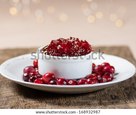 Bowl of fresh cranberry sauce with whole cranberries on white plate