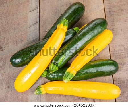 Zucchini and yellow squash on a wooden table overhead