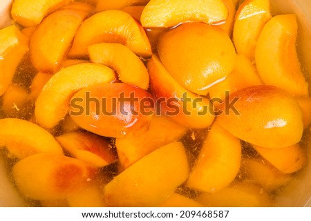 Bowl of fresh sliced yellow peaches in a bowl of clear syrup
