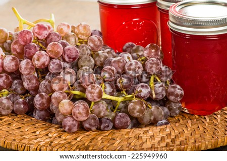 Jars of fresh pink grape jelly with grapes