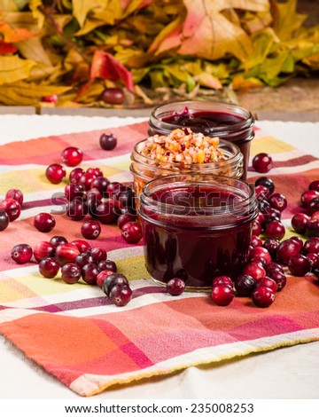 Jars of cranberry sauce with cranberries and apple relish on a table