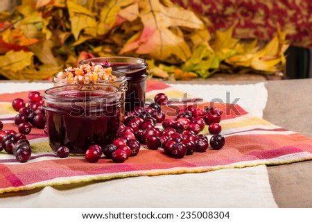 Jars of cranberry sauce with red cranberries on a table