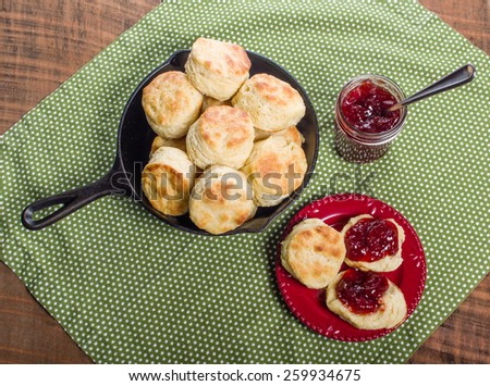 Cast iron skillet of fresh biscuits or scones with jam or jelly