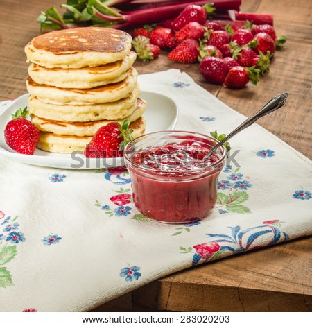 Stack of pancakes on plate with strawberry rhubarb jam