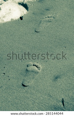 Footsteps on a lonely beach in the sand black and whie