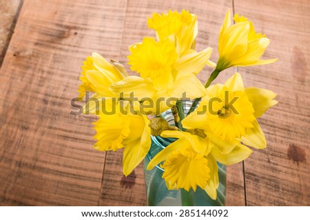 Bouquet of fresh yellow daffodil flowers in a blue mason jar