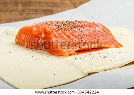 Salmon fillet seasoned and wrapped in dough ready to bake