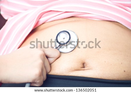 examination abdomen by doctor and use stethoscope