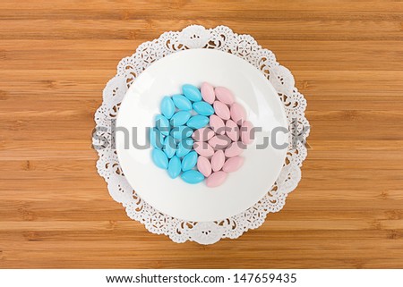 Blue and pink pills on a bone china saucer, arranged in a shape of yin and yang