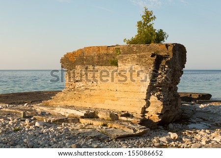 Huge rock with juniper tree on top of it on a shore of Lake Huron, Bruce Peninsula, Ontario, Canada