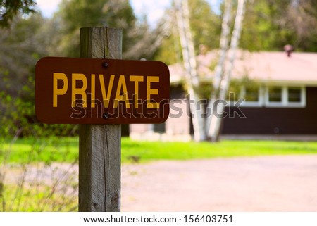 Private Residence Sign in Park Area, with an out of focus residential house on a background