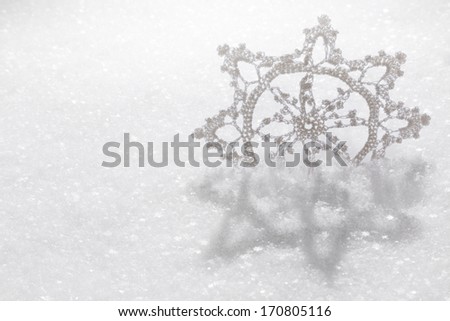 A hand-crafted fabric snowflake on a fresh snow
