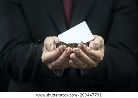 Blank Business card in hands on the ground