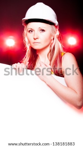 Young architect woman construction worker holding empty poster, glowing lights