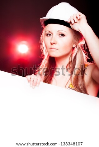 Young architect woman construction worker holding empty poster, glowing lights