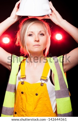 Young architect woman construction worker holding safety helmet, glowing lights