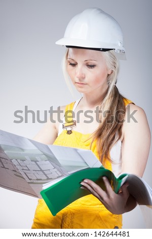 Young architect woman construction worker with blueprints plan