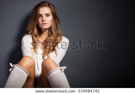 Natural young woman wearing socks and white long sleeve t-shirt, sensual looking