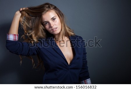 Sexy woman pulls hair on dark background