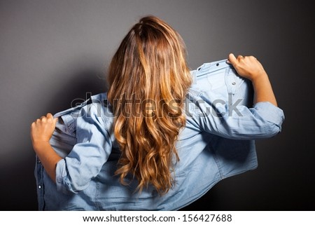 Sexy woman standing back in denim jeans jacket or shirt