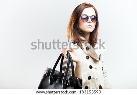 Elegant woman in white coat with black leather bag