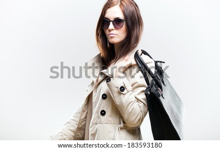 Elegant woman in white coat with black leather bag