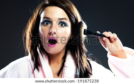 Funny surprised woman in bathrobe and make up cosmetic powder brush