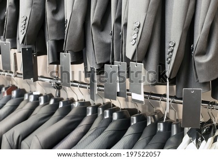 Row of elegant suits jacket on hangers in apparel store