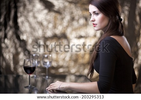 Glamour woman sitting alone in luxury restaurant