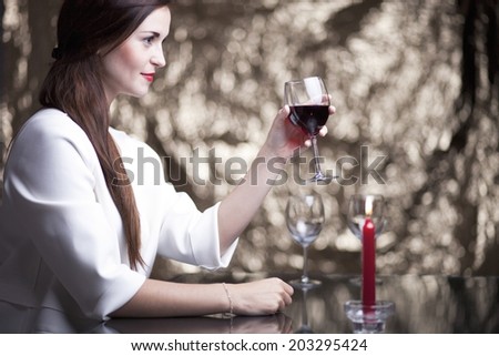 Elegant glamour woman in restaurant with glass of red wine