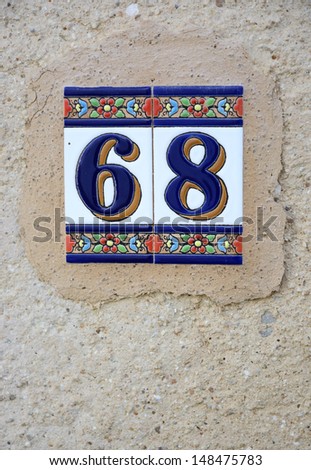 Ceramic tile Ibiza style with the number \'68\' on a wall, grungy, hippie style texture background