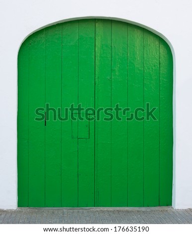 Texture background or design element - green painted door with hatch and rounded top on whitewashed wall, Majorca, Spain.