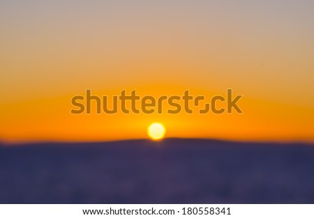 Colorful Sunset Blur , expressionistic style, with centered setting sun on blue or purple earth, water and yellow sky. Mediterranean, Mallorca, Balearic islands, Spain.