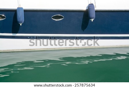 Marine details and colors closeup of beautiful marine blue sailboat or yacht in green water Mallorca, Balearic islands, Spain.