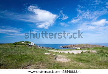 FALKENBERG, SWEDEN - JUNE 5, 2015: Small wood boat in rocky coastal landscape and fisherman\'s house on the heath on June 5 in Skrea, Falkenberg, Sweden.