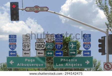 FLAGSTAFF, ARIZONA, UNITED STATES - JULY 24, 2008: Road signs at a crossroad on Route 66 with red light going east or west on July 24, 2008 in Flagstaff, Arizona, United States.