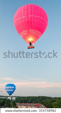 STOCKHOLM, SWEDEN - JULY 26, 2011: Air balloons with advertising logos by Atlas Copco and Ballongflyg Upp & Ner take off in the evening sky on July 26, 2011 over Stockholm, Sweden.
