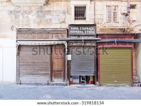 VALLETTA, MALTA - SEPTEMBER 15, 2015: City scene in the streets of Valletta with old architecture and vintage store fronts on a sunny day in September 15, 2015 in Valletta, Malta.